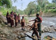 Jembatan Belum Terbangun, Babinsa Antar Anak-Anak Sekolah Menyebrang Sungai dengan Rakit Bambu di Tapua