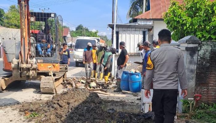 Bhabinkamtibmas Madatte Dampingi Pengangkatan Sedimen Drainase di Jalan Mr. Muh. Yamin