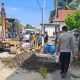Bhabinkamtibmas Madatte Dampingi Pengangkatan Sedimen Drainase di Jalan Mr. Muh. Yamin